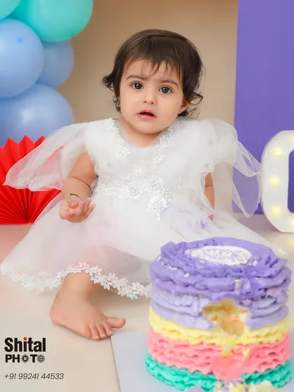A look of curiosity at the colorful rainbow cake. This is the moment right before the smashing begins.