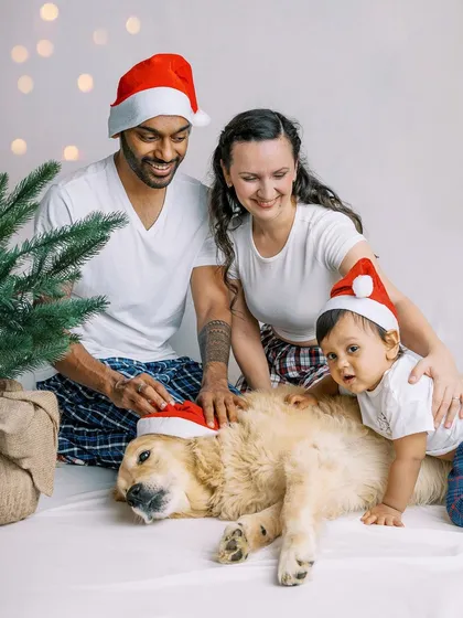 A fun, festive Christmas photo with the whole family, including their baby and their golden retriever. My studio-on-the-go setup allows us to create these memories right in your home.