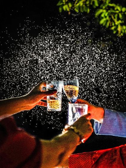 A toast to the new beginning! This creative shot captures the spray of champagne as friends celebrate the couple's engagement, freezing a moment of celebration.