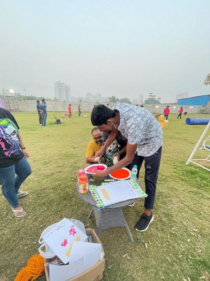 A staff member helping a guest and their furry friend make the perfect paw print. We're always on hand to help with activities.
