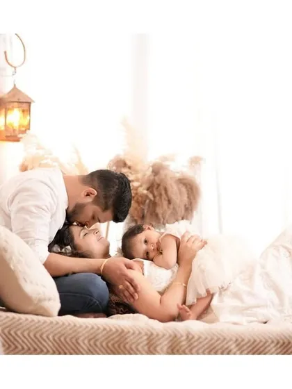 An intimate and loving family portrait. This overhead shot captures a tender kiss and a quiet cuddle, creating a beautiful memory of their bond.