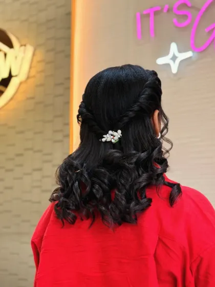 A simple yet elegant hairstyle with twisted-back sides and soft curls. The pearl barrette adds a touch of class to this look, perfect for any occasion.