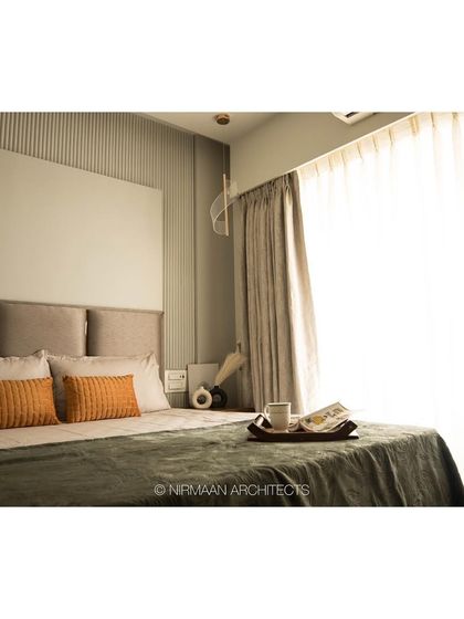Natural light fills this master bedroom, highlighting the textures of the bedding and the fluted wall detail. We always try to maximize daylight to make spaces feel bright and positive.