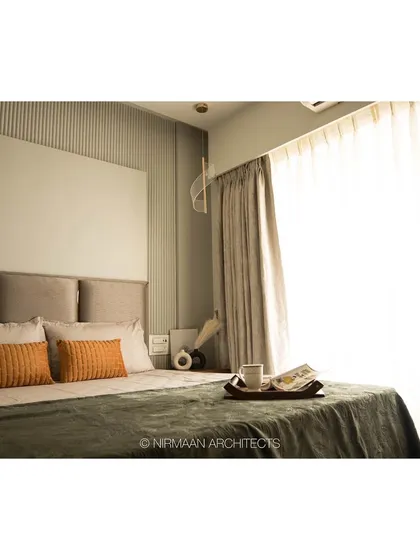 Natural light fills this master bedroom, highlighting the textures of the bedding and the fluted wall detail. We always try to maximize daylight to make spaces feel bright and positive.