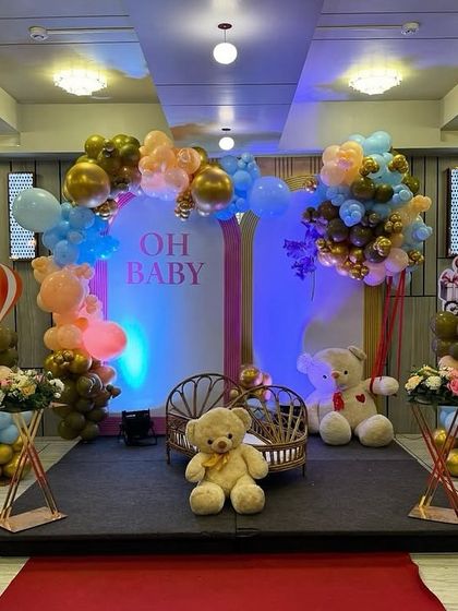 A cozy shot of the 'Oh Baby' stage with multiple teddy bears and a baby cradle, creating a warm and inviting atmosphere.