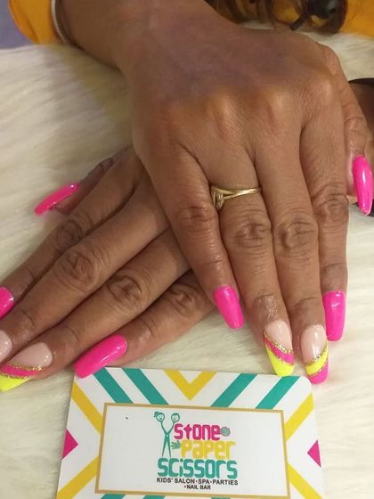 Go bright or go home. This set features neon pink nails with a vibrant yellow and glitter accent on the tips, creating a bold and summery look on long square extensions.