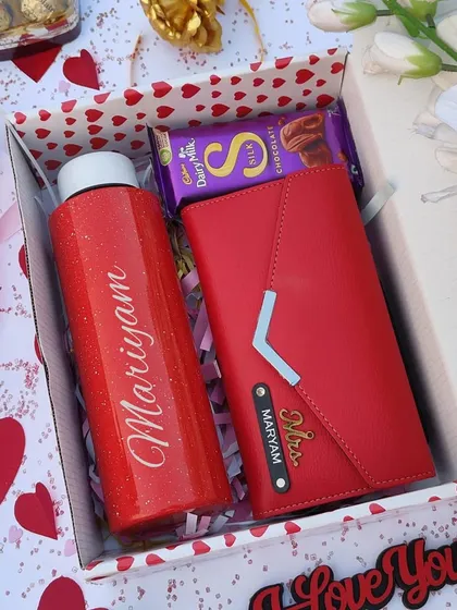 A simple yet elegant Valentine's combo for her. This set includes a personalized red sparkle flask, a custom three-fold clutch, and a Cadbury Silk chocolate bar, all in a gift box.
