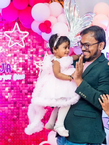 The birthday girl gets a high-five from her father in this lovely family interaction shot from her first birthday celebration.