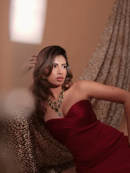 A candid shot of Aashna Hegde, showcasing the vibrant green of the Mehrani necklace set, a piece designed for making a statement.