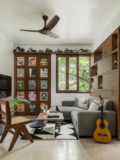 We love adding a cheeky surprise to our designs. In this family living room, what looks like a wall of curated movie and music posters is actually a hidden bar, perfect for entertaining.