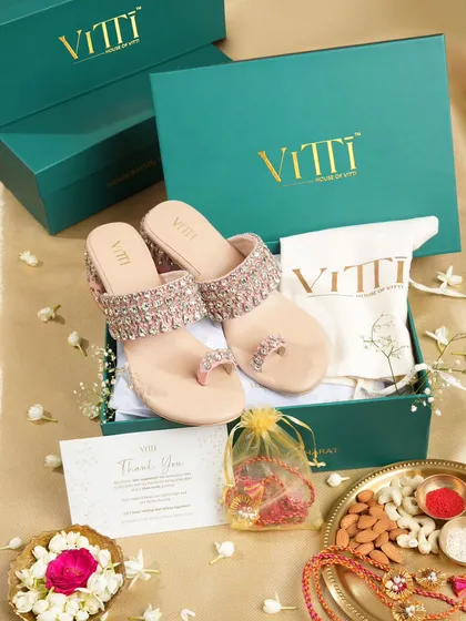 A festive flat lay for a Rakshabandhan campaign, featuring embellished sandals in a gift box. The styling includes a rakhi and traditional thali to create a complete festive story.