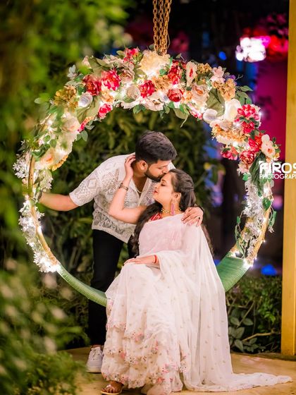 A tender kiss on the forehead on the floral swing, a perfect candid moment.