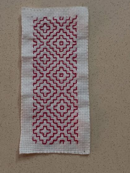 A simple yet elegant Kasuti pattern in a single color. Even with basic designs, the precision of the counted stitch creates a striking effect.