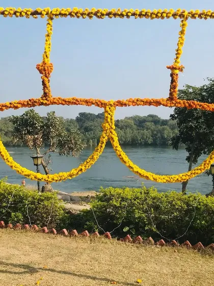 A quirky and fun photo prop for a Haldi ceremony, shaped like oversized sunglasses and made entirely of marigold flowers.
