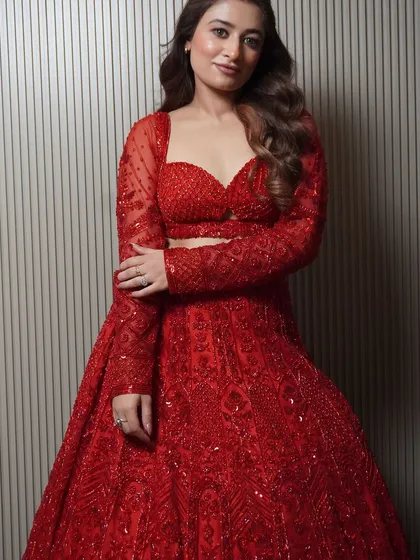 This full-length view shows the gorgeous flare and intricate hand embroidery of our new red lehenga. It's a piece that combines modern style with traditional craftsmanship.