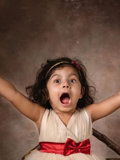 A huge, expressive "hurray!" This photo is all about capturing the pure, uninhibited joy of a child during our fun and interactive studio session.