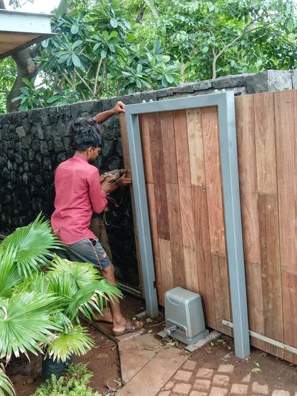The installation of a custom-designed wooden gate. This piece combines a modern steel frame with traditional wood planking, creating a secure and stylish entrance that complements the property's blend of old and new.