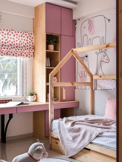 This angle shows the dual study desk in the girls' pink bedroom, providing a dedicated workspace for two, complete with storage and a view from the window.