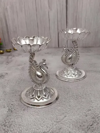A pair of German silver peacock diyas with a lotus-shaped base, a new and elegant design in our collection.