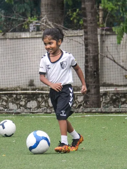 A smile of accomplishment during a training session. We celebrate small wins and encourage a positive attitude, making learning football an enjoyable experience for every child.