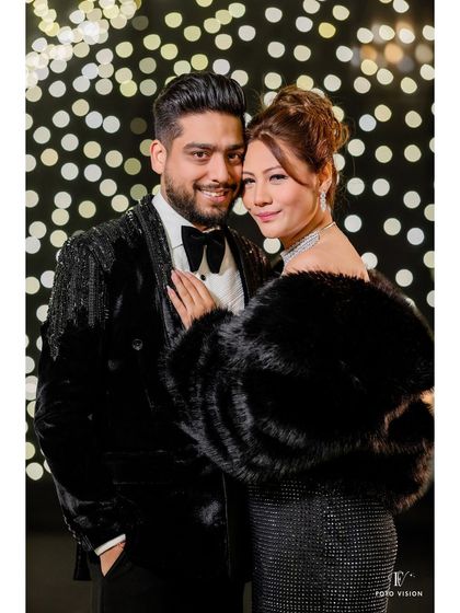 A classic portrait of the couple against a stylish, lit backdrop, exuding elegance and old-school glamour.