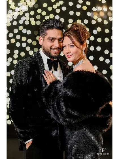 A classic portrait of the couple against a stylish, lit backdrop, exuding elegance and old-school glamour.
