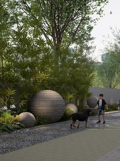 A pet-friendly pathway in a Bengaluru residential project, featuring a mix of gravel and paved surfaces. The design incorporates large, textured spherical sculptures and layered plantings, creating a visually interesting and tactile experience for residents and their pets.