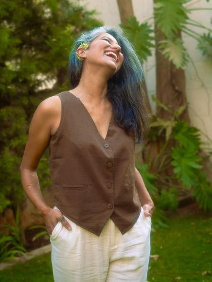 The waistcoat and white trousers combination is a perfect example of sustainable, chic summer wear.