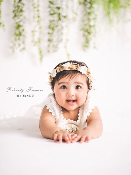 The sweet curiosity of a six-month-old. This tummy time pose is perfect for showing off their strength and capturing their upward gaze.