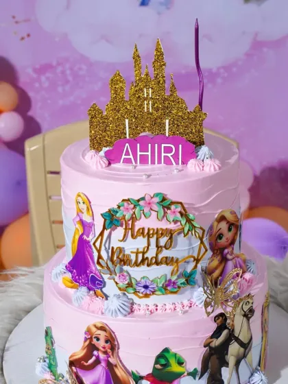 A close-up of the Rapunzel cake, ready for the birthday girl with a candle sparkling on top.