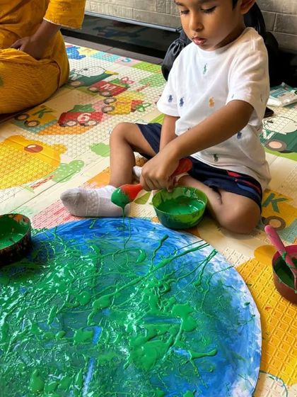 Another perspective of our Earth Day finger painting fun. Using different shades of green and blue paint, this child is creating his own version of our beautiful planet.