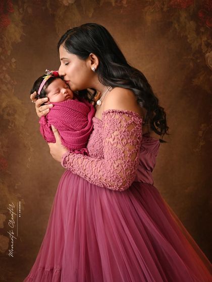 A close-up of a mother kissing her sleeping newborn's forehead. This simple, loving gesture is a powerful symbol of the connection between a mother and her new baby.