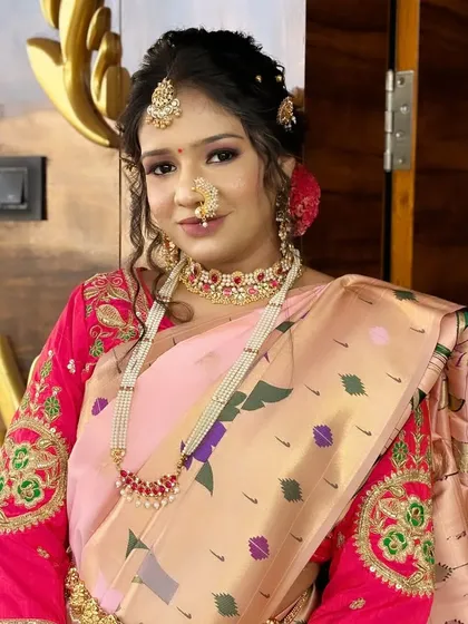 A classic portrait of a Maharashtrian bride, showcasing the traditional `nath` and the detailed embroidery on her blouse.