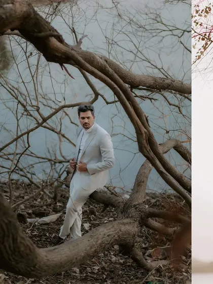 A stylish portrait of the groom-to-be posing amongst the dramatic, bare branches of a tree by the water's edge.