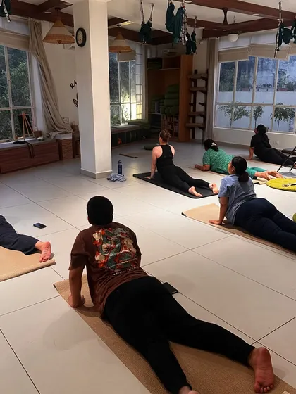 A class practices Cobra Pose, opening their chests and strengthening their backs.
