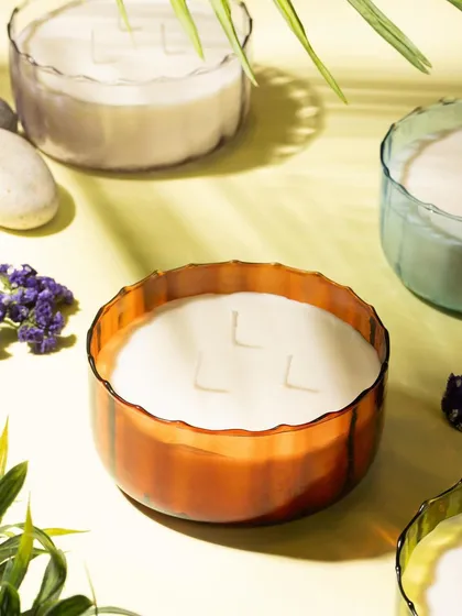 A group shot of several large, multi-wick candles from Lighthouse. The composition and lighting highlight the different colors and textures of the glass jars.