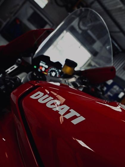 The iconic Ducati logo on the bright red tank of a Panigale V4.