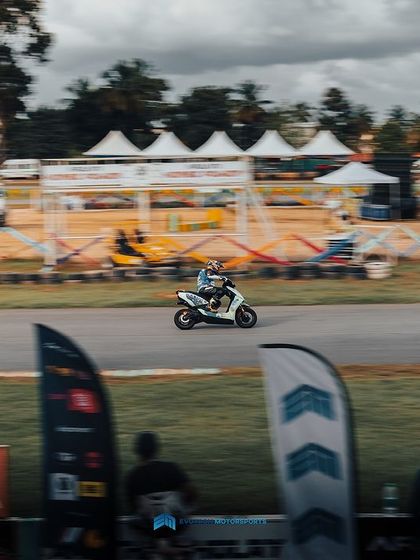 A motion-blurred shot of an Ather electric scooter at speed on the track. These machines are surprisingly quick and make for some intense racing.