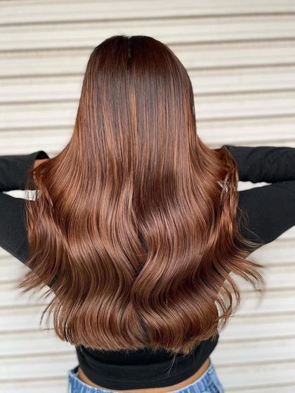 The back view of this Peanut Brown hair color showcases the depth and richness of the tones. The soft waves highlight the blend of warm browns and caramels beautifully.