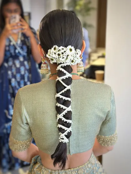 A clear, detailed view of the pearl-wrapped braid, a technique that adds a touch of modern elegance to a traditional hairstyle.