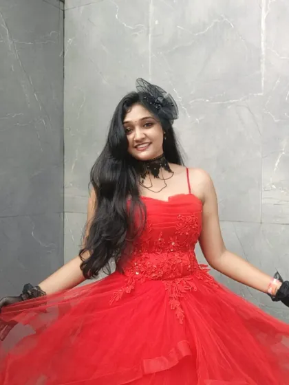A happy smile from a client wearing our red ball gown. The spaghetti straps and layered tulle skirt create a classic and celebratory look.