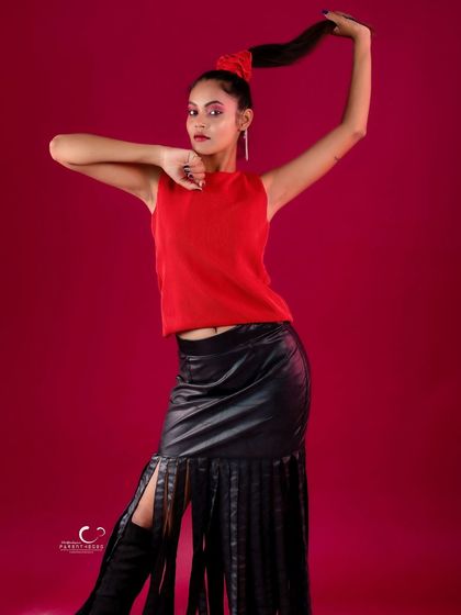 A strong and confident pose that highlights the textures of the outfit, from the knit top to the leather fringe.