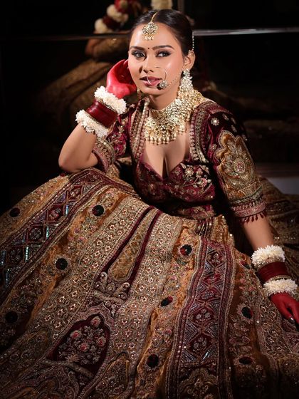 A full length shot showcasing a stunning bride in her heavily embroidered lehenga. The makeup is designed to be bold enough to stand out while still looking elegant and timeless.