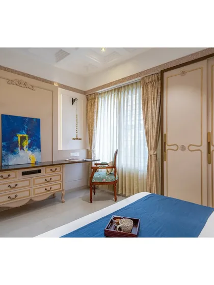 This view shows the integration of a functional study or vanity area within the bedroom, featuring a classic console table and chair that match the room's aesthetic.