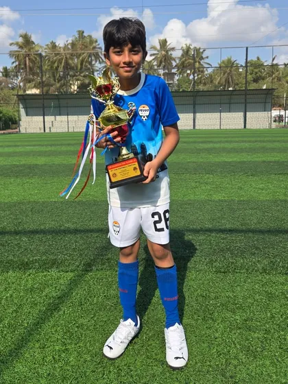 This U12 player is all smiles with his championship trophy.