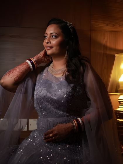 A warm, intimate portrait. The soft lighting enhances the glow of her skin, and the makeup gives her a polished and elegant appearance for her evening event.