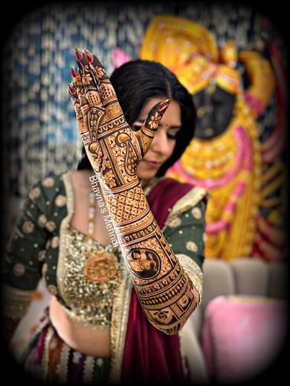 A close-up of the bride's hand, highlighting the fine lines and detailed motifs that make our bridal mehndi special.