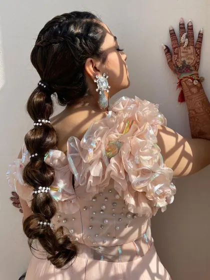 A sun-kissed shot of the bubble ponytail, showing how the pearls catch the light.