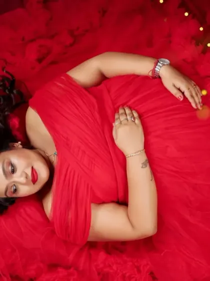 A vibrant overhead shot of the mom-to-be resting on a sea of red fabric. The rich color and soft lighting create a passionate and beautiful image.