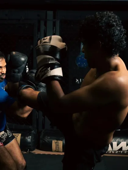 A focused shot of a high kick being blocked, showing the split-second reactions needed in a fight.